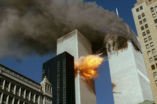 Smoke pours off one of the towers of the World Trade Center as flames explode from the second one as it is struck by a plane Tuesday, September 11, 2001. (AP/Chao Soi Cheong)