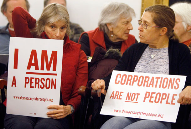 Critics of <i>Citizens United</i>, which paved the way for an enormous influx of money into this year's political cycle, hold signs during a gathering on the anniversary of the ruling. (AP/ Toby Talbot)
