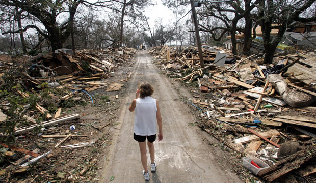 Rhonda Braden walks through the destruction brought by Hurricane Katrina in her childhood neighborhood on August 31, 2005, in Long Beach, Mississippi. (AP/Rob Carr)