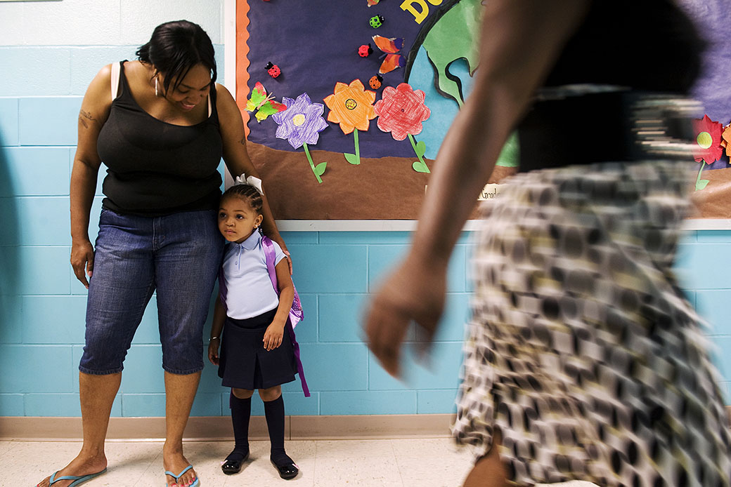 A 3-year-old stands with her aunt during her first day of prekindergarten, August 2011, in Landover, Maryland. (Getty/Amanda Voisard)
