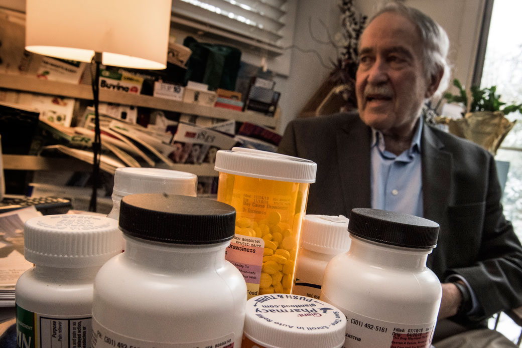 A man, who has Parkinson's disease, sits behind his daily medications at his home in Bethesda, Maryland, on February 1, 2019.