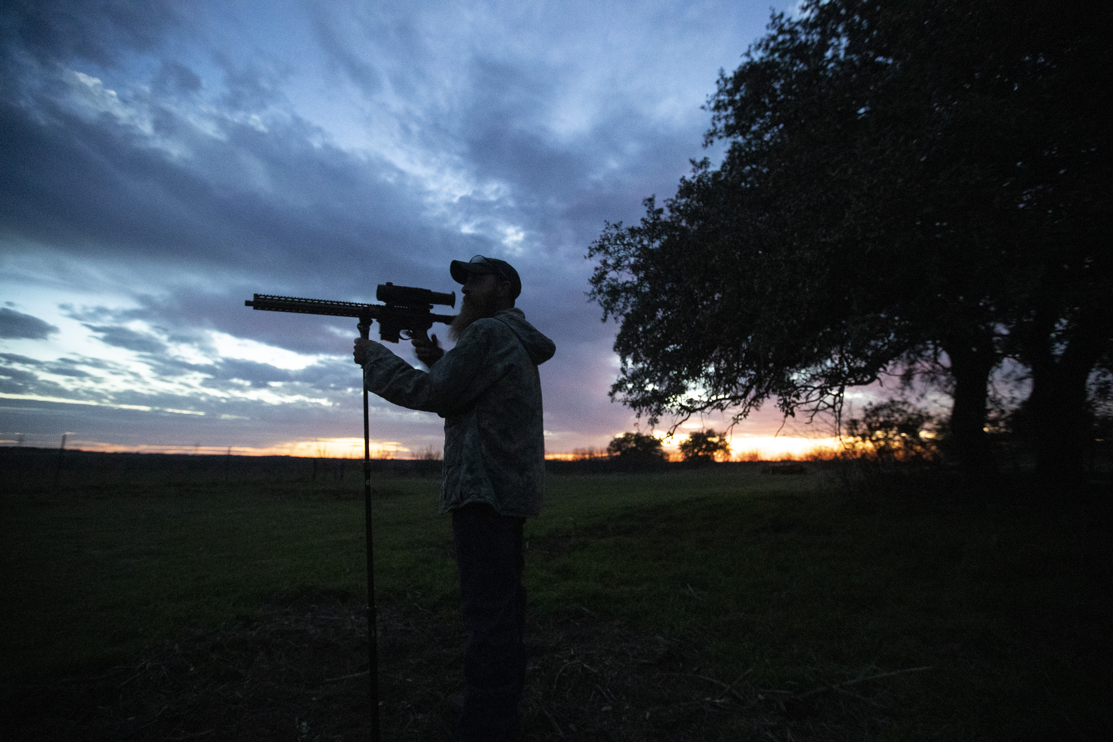 A man peers through the scope on his rifle in rural Texas.