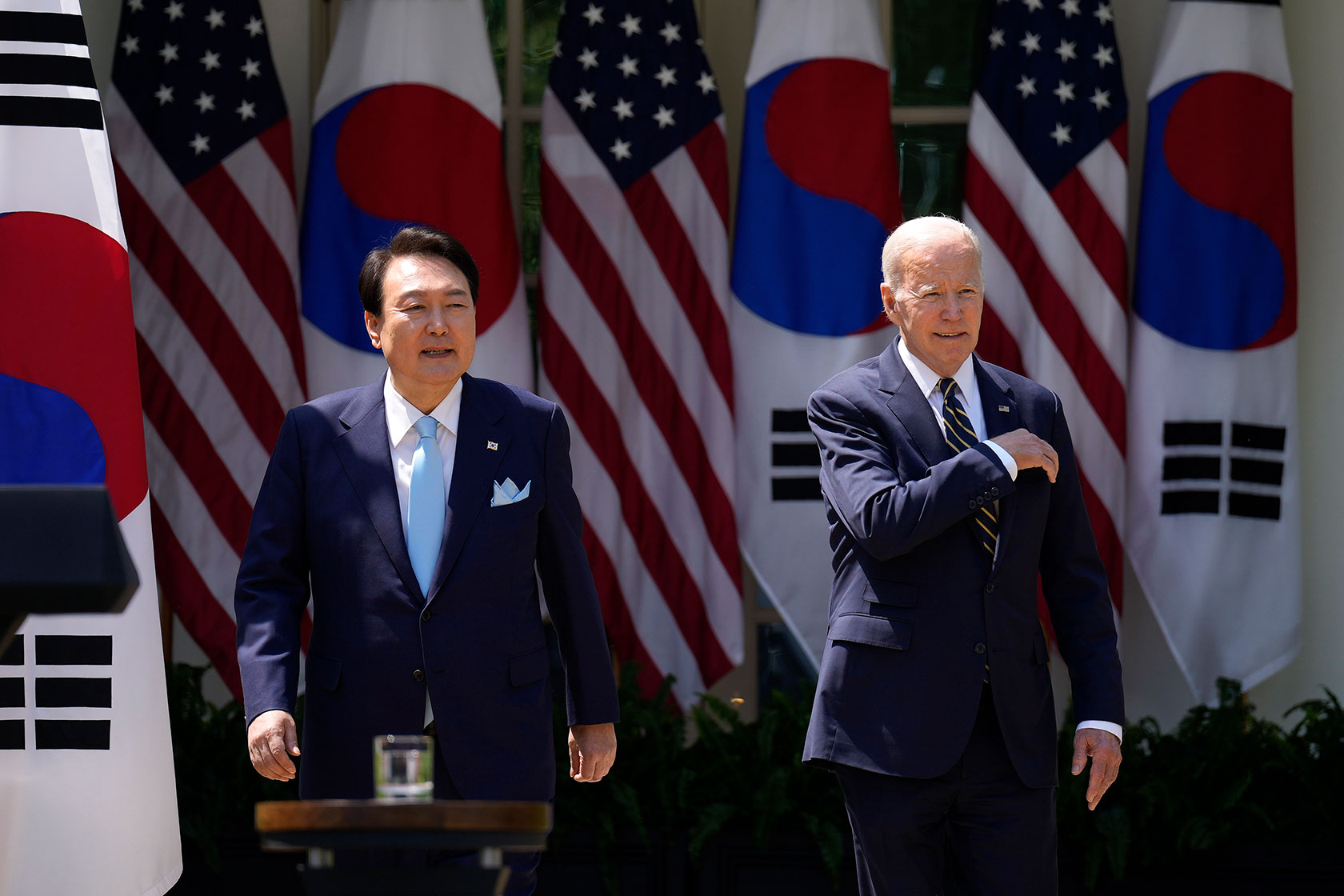 Presidents Yoon and Biden in front of U.S. and South Korean flags