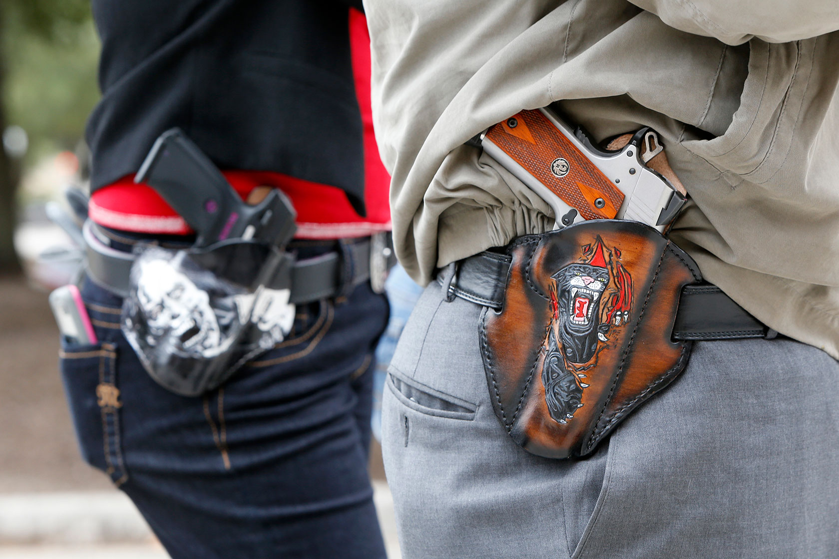 Pistols are seen in custom-made holsters during a rally.